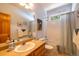 A charming bathroom with an oak vanity, sink, and toilet with tub and shower at 6752 S Columbine Rd, Evergreen, CO 80439