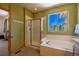 Bathroom with a tub and shower combo with a bright window view at 6752 S Columbine Rd, Evergreen, CO 80439