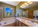 Bathroom featuring double sink vanity, separate shower, and tub with jets at 6752 S Columbine Rd, Evergreen, CO 80439