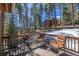 Relaxing deck with comfortable seating surrounded by lush pine trees at 6752 S Columbine Rd, Evergreen, CO 80439