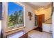 Bright entryway features tiled floors, wood door, storage bench, and scenic view from window at 6752 S Columbine Rd, Evergreen, CO 80439