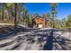 Secluded home with natural wood siding, surrounded by lush trees in a quiet neighborhood at 6752 S Columbine Rd, Evergreen, CO 80439