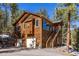 Wood home exterior featuring an attached garage and staircase leading to the entrance at 6752 S Columbine Rd, Evergreen, CO 80439