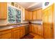 Kitchen featuring wooden cabinets, countertop, sink and a view of the outside through the window at 6752 S Columbine Rd, Evergreen, CO 80439