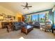 Living room featuring dual sofas, a ceiling fan, and an abundance of natural light from the large window at 6752 S Columbine Rd, Evergreen, CO 80439
