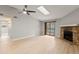 Bright living room features a stone fireplace, ceiling fan, skylight, and sliding glass doors at 8600 E Alameda Ave # 22-208, Denver, CO 80247