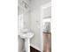 Clean, white bathroom featuring a pedestal sink and bright lighting at 12714 E Dickenson Ave, Aurora, CO 80014