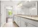 Bright bathroom featuring dual granite vanities, chrome hardware, large mirrors, and a walk-in glass shower at 12714 E Dickenson Ave, Aurora, CO 80014