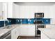 Modern kitchen with stainless steel appliances, granite countertops, and a stylish backsplash at 12714 E Dickenson Ave, Aurora, CO 80014