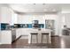 Bright kitchen with white cabinets and a large center island with seating at 12714 E Dickenson Ave, Aurora, CO 80014