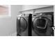 Modern black front load washer and dryer with a grey wall background and a window bringing in natural light at 12714 E Dickenson Ave, Aurora, CO 80014