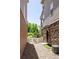 A welcoming side yard with stone and wood siding, a quaint white picket fence, and vibrant green foliage at 12714 E Dickenson Ave, Aurora, CO 80014