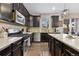 Updated kitchen with stainless steel appliances, dark cabinets, and a center island with quartz countertop at 713 San Juan Dr, Lafayette, CO 80026