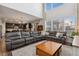 Open floor plan showcases living room with large sectional, hardwood floors, and kitchen area at 713 San Juan Dr, Lafayette, CO 80026