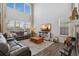 Bright living room with large windows, hardwood floors, and a comfortable leather sectional at 713 San Juan Dr, Lafayette, CO 80026