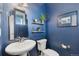 Stylish powder room with a pedestal sink, decorative mirror, and blue walls at 713 San Juan Dr, Lafayette, CO 80026