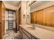 Bathroom with patterned tile floor, vanity, and closet with organizing shelves at 9295 W 80Th Pl # A, Arvada, CO 80005