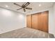 Cozy bedroom with tan carpeting, ceiling fan, and a closet with wood sliding doors at 9295 W 80Th Pl # A, Arvada, CO 80005