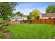 Well-manicured lawn and mature trees surround the fenced backyard, offering a private retreat at 6342 Marshall St, Arvada, CO 80003