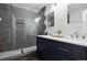 Modern bathroom boasting double vanity with gray cabinets and shower with gray and white tile and glass enclosure at 6342 Marshall St, Arvada, CO 80003
