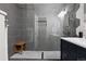 Modern bathroom showcasing sleek gray tiles, a glass-enclosed shower, and a navy blue vanity with white countertops at 6342 Marshall St, Arvada, CO 80003