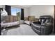 Cozy bedroom features two cribs, a leather recliner, a large window, and gray carpet at 6342 Marshall St, Arvada, CO 80003