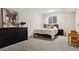 Simple bedroom with a double bed, gray carpet, dresser, and a window overlooking a basement egress at 6342 Marshall St, Arvada, CO 80003