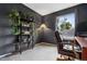 Dark painted bedroom with a large desk, comfortable chair and open shelving with plants at 6342 Marshall St, Arvada, CO 80003