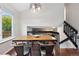 Open dining area with hardwood floors, modern lighting fixture, next to the staircase at 6342 Marshall St, Arvada, CO 80003