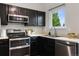 Modern kitchen features stainless steel appliances, black cabinets and light countertops at 6342 Marshall St, Arvada, CO 80003
