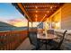Relaxing covered patio with wood pergola, overhead string lights, and an outdoor dining set at 8048 Grady Cir, Castle Rock, CO 80108
