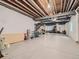 Unfinished basement featuring concrete floors, exposed beams, white walls, and ample open space at 15347 Quince Cir, Thornton, CO 80602