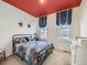 Cozy bedroom with a red accent ceiling, decorative stars, and a comfortable quilt at 15347 Quince Cir, Thornton, CO 80602