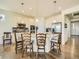 White kitchen island featuring pendant lighting and seating, open to appliances and adjacent rooms at 15347 Quince Cir, Thornton, CO 80602