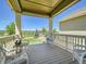 Relaxing covered porch with wicker chairs and a scenic view of the backyard at 15347 Quince Cir, Thornton, CO 80602
