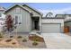 Charming home with a gray exterior, attached garage, and modern landscaping at 1464 Orchard St, Brighton, CO 80601