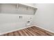 A functional laundry room with wood floors, shelving, and hookups at 1464 Orchard St, Brighton, CO 80601