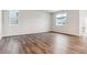 Bright living room with sleek floor, white walls and two windows at 1464 Orchard St, Brighton, CO 80601