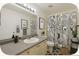 This bathroom features a long vanity with ample lighting and shower/tub combo at 2644 Devonshire Ct, Denver, CO 80229