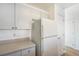 Bright kitchen featuring white cabinets, modern appliances, and wood-look flooring at 2644 Devonshire Ct, Denver, CO 80229