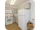A bright kitchen features white appliances, cabinets, and countertops in a cozy space at 2644 Devonshire Ct, Denver, CO 80229