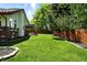 Manicured backyard featuring a spacious lawn, patio, and wooden fence at 3608 S Newport Way, Denver, CO 80237
