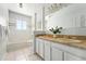 Bathroom with dual sinks, large mirror, and tub with shower at 3608 S Newport Way, Denver, CO 80237