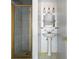 Bathroom featuring a pedestal sink and shower with glass doors at 3608 S Newport Way, Denver, CO 80237