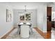 Elegant dining room featuring a modern chandelier, table with chairs, and natural light from the window at 3608 S Newport Way, Denver, CO 80237