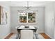 Chic dining room with a modern chandelier, stylish table and chairs, and a large window with backyard views at 3608 S Newport Way, Denver, CO 80237