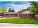 Charming brick home featuring a well-maintained lawn and colorful landscaping, complemented by a classic tile roof at 3608 S Newport Way, Denver, CO 80237