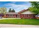 Charming brick home with well-manicured lawn and flower beds at 3608 S Newport Way, Denver, CO 80237