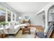 Bright living room with a white sofa, hardwood floors, and natural light flowing in from the large windows at 3608 S Newport Way, Denver, CO 80237
