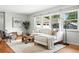 Inviting living room with a plush white sectional sofa, light hardwood floors, and lots of natural light at 3608 S Newport Way, Denver, CO 80237